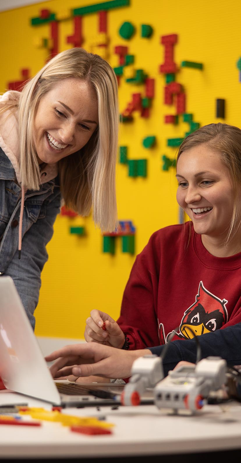 Two students work with Legos and components in a maker space