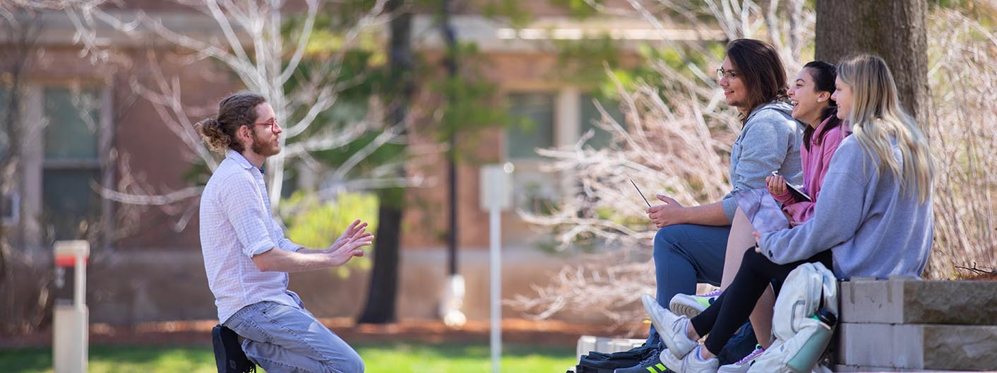 Students participate in a small group discussion outside during English class