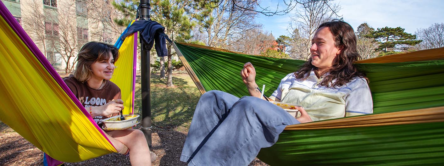 A student relaxes in a hammock on campus