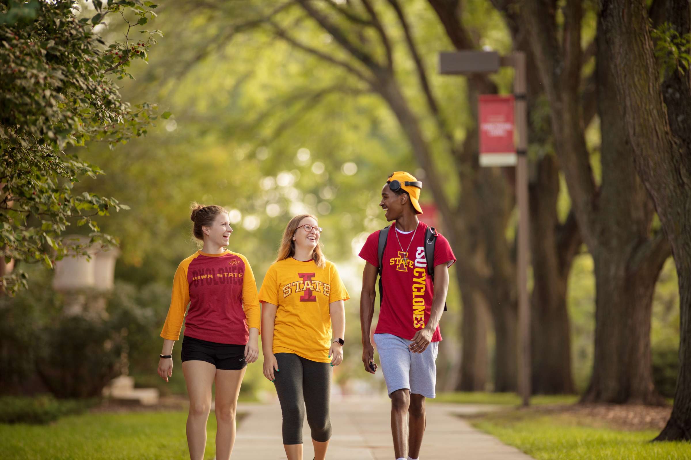 Three students walking on campus. 