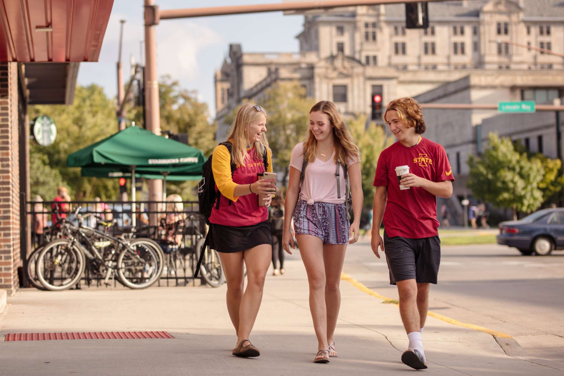 Three students walking outside of Starbucks. 