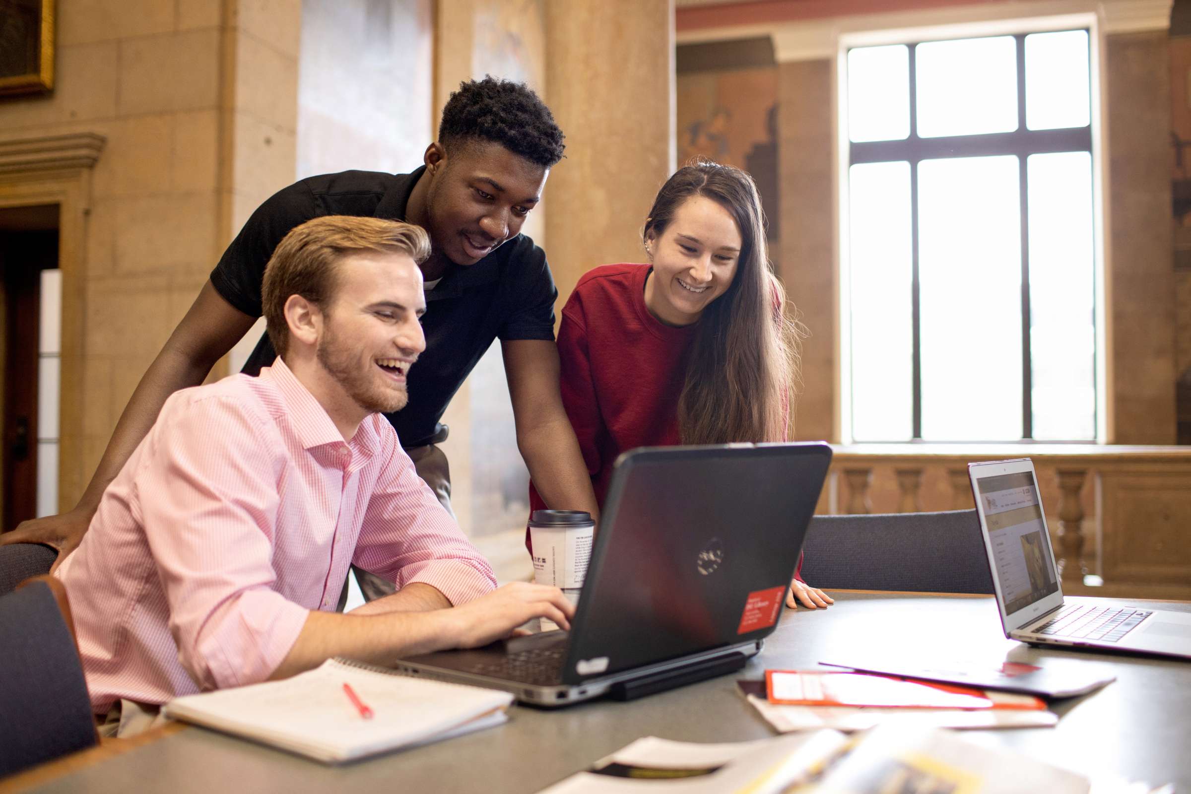 Three students looking at laptop in Parks Library. 