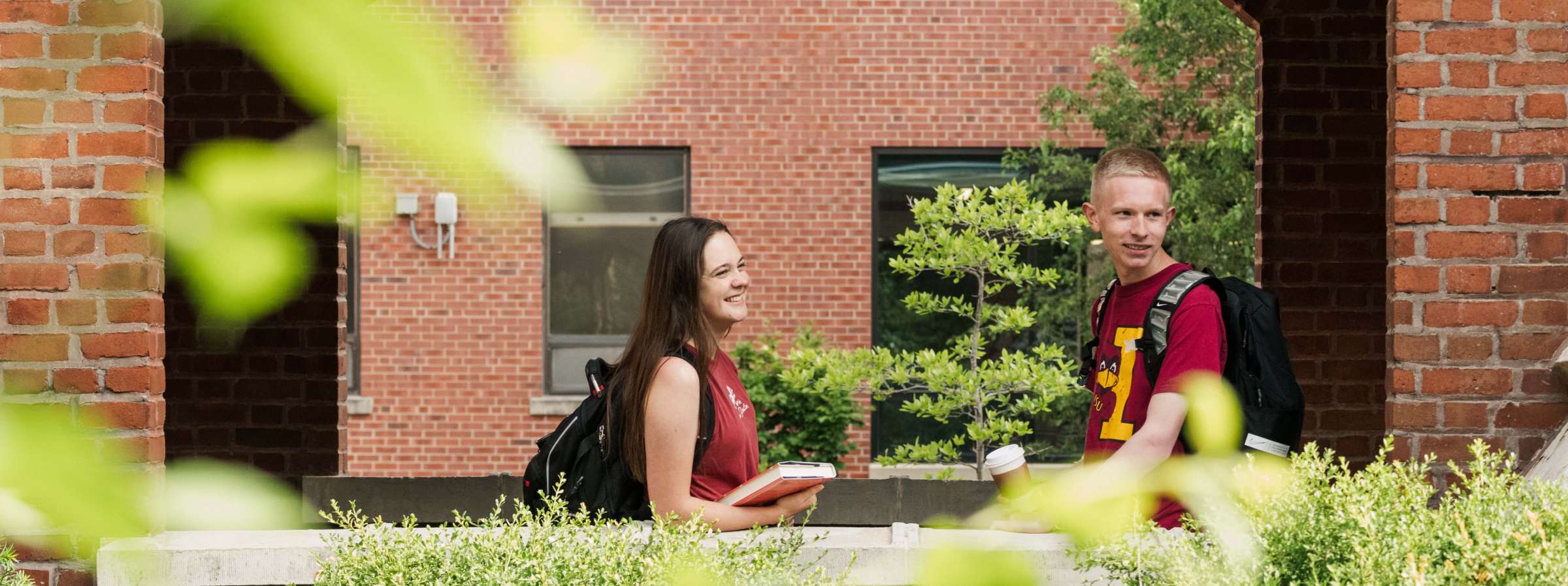 Two students sitting by Lagomarcino arches. 